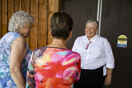 Two patrons being greeted at the theatre entrance by a friendly usher